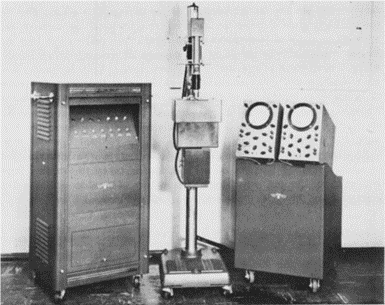 Figure 2.1. The Cytoanalyzer in 1955 [43]. On the left is the “power supply and computer,” in the centre is the scanner, and on the right are oscilloscopes “for data-monitoring and presentation.”
